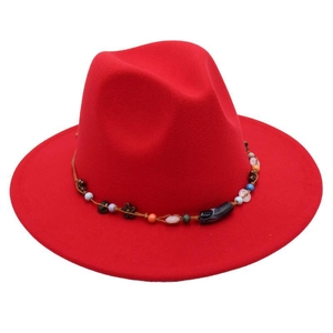 Detail of red wide-brim fedora hat featuring an ethnic handmade beaded decorative band