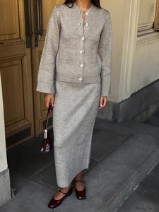 Detail of grey knitted cardigan and skirt set featuring premium texture and button design