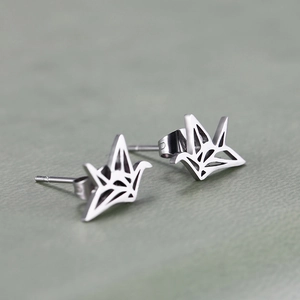 Macro detail of geometric hollow origami crane stud earrings in polished silver finish