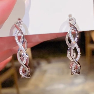 Macro view of silver infinity twist hoop earrings featuring pave-set sparkling zircons