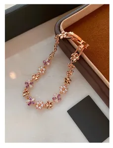 Detailed macro view of rose gold flower bracelet with purple crystals and white pearls