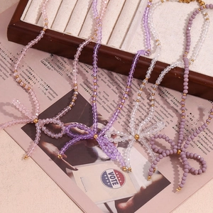 Detail of beaded bow necklaces with transparent crystal beads in multiple pastel colors