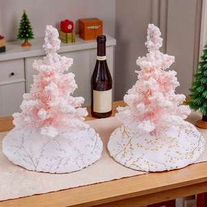 Mini pink flocked Christmas trees with white plush tree skirts in gold and silver leaf patterns