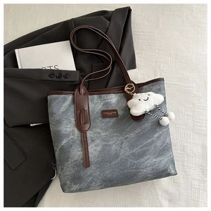 Detail view of large tote bag with dark grey marble texture and plush cloud pendant
