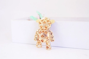 Close-up of golden bear keychain with floral hollow design and blue rhinestones