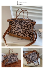 Close-up of leopard print canvas bag with brown leather trim and metal rivets