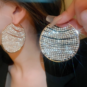 Macro detail of luxury oversized round earrings with sparkling cubic zirconia pavé