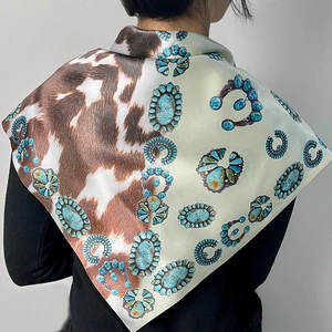 Detail of silk scarf featuring western turquoise jewelry patterns and cow print design