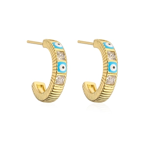 Detail of C-shaped gold-plated earrings with blue evil eye charms and cubic zirconia