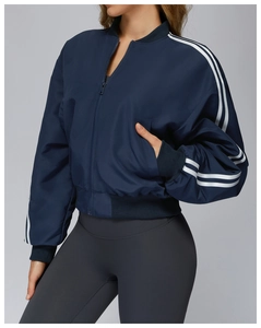 Dettaglio della giacca sportiva blu navy con strisce bianche e polsini a costine