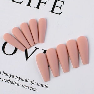 Macro shot of matte nude pink long coffin-shaped press-on nails with frosted texture finish