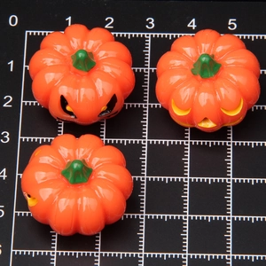 Luminous orange Halloween pumpkin ornaments with green stems on a measuring grid