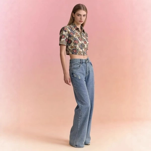 Jean femme taille haute droite avec top court fleuri sur un fond dégradé chaleureux