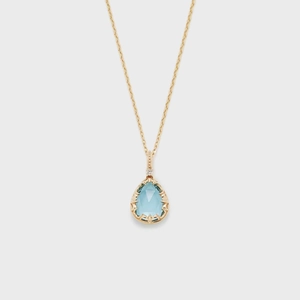 Makro-Detail eines blauen Edelsteinanhängers in einer Vintage-Gold-Filigran-Fassung