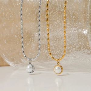 Detail of gold and silver beaded necklaces with round pearl pendants in water bubbles