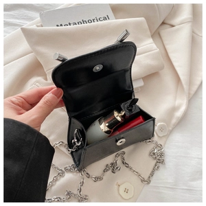 Interior detail of a mini black leather crossbody bag showing space for a lipstick