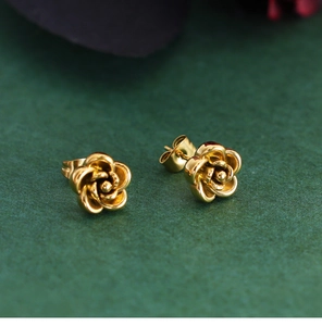 Macro view of gold rose-shaped vintage stud earrings with layered metallic petals