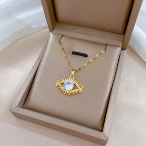 Elegant gold eyelash eye necklace with a large round cubic zirconia in a jewelry box