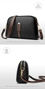 Detail view of black pebble leather shell bag with brown straps and golden zippers