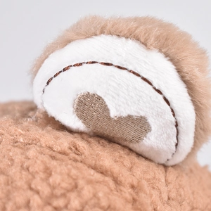 Macro shot of plush brown baseball cap ear with white fabric lining and heart embroidery