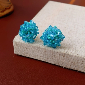 Macro shot of blue beaded cluster earrings featuring faceted crystal and woven beads