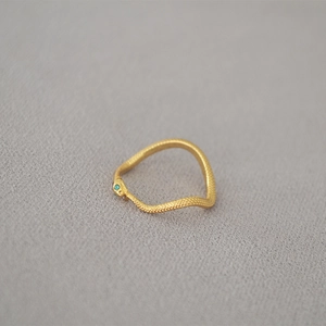 Chic gold wave snake ring with green gem eyes and scaled texture on metal band
