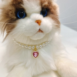 Close-up of pearl pet necklace with pink heart crystal pendant on a cat model