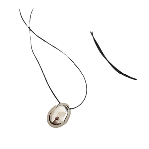 Minimalist silver pebble pendant necklace with black leather cord on white background