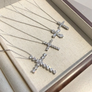 Detailed view of S925 silver necklaces with various zircon cross pendants on tray