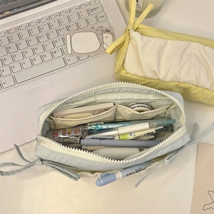 Detail view of large capacity fabric pencil cases with ribbon bows and internal dividers