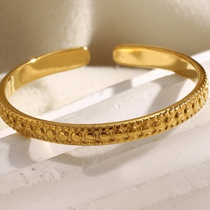 Minimalist 18K gold plated beaded open ring with embossed dots on white stone background
