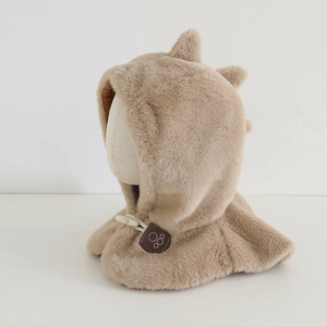Dettaglio macro del cappello dinosauro in peluche con bottone in legno e morbido pelo