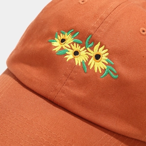 Orange baseball cap featuring fine sunflower embroidery on premium cotton twill fabric