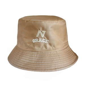 Close-up of white letter embroidery and fine texture on a khaki bucket hat surface
