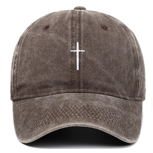 Detailed view of white cross embroidery on vintage washed cotton baseball cap