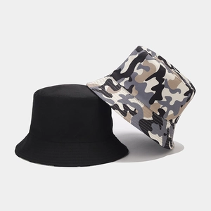 Detail of dual-sided bucket hats featuring solid black and camouflage twill fabric