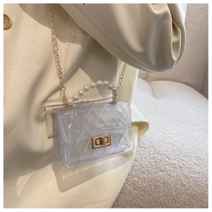 Detail of white jelly bag with diamond lattice pattern, pearl handle, and gold chain