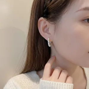 Elegant pearl hoop earrings with gold metal buckle clasp on female model