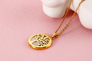 Macro shot of gold-tone tree of life pendant with white mother of pearl inlay on chain