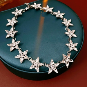 Dettaglio della collana a stella con strass scintillanti su portagioie verde scuro
