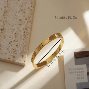 Detailed size and weight view of a gold bangle with star engraving and crystals