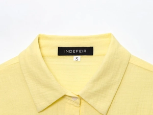 Detail of soft yellow cotton linen shirt collar with standard lapel and size S tag