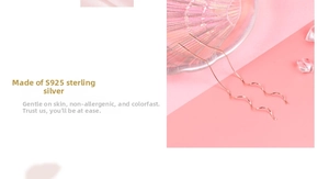 Macro detail of long S925 sterling silver wave earrings in rose gold on pink decor
