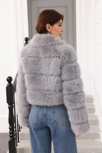 Detail of grey faux fur coat showing plush texture and short-cut multi-layer stitching