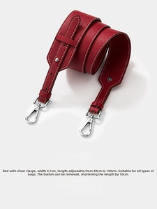 Detail of red pebbled leather bag strap with silver buckles and 4.1cm width dimension