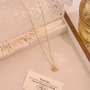 Elegante goldene Schmetterlings-Halskette mit Zirkonia auf einem Holztablett