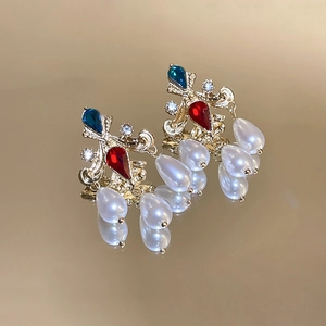Detailed view of vintage gold earrings with colorful rhinestones and pearl tassels