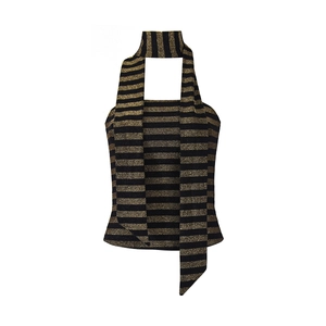 Detalle de top halter a rayas negro y dorado metalizado con lazos largos y textura de punto