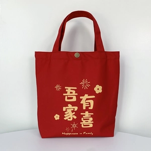 Detail of red wedding canvas bag with gold buckle and festive gold lettering print