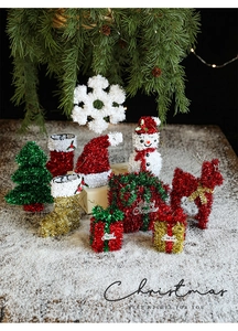 Glittery Christmas ornaments including reindeer and snowman on faux snow background